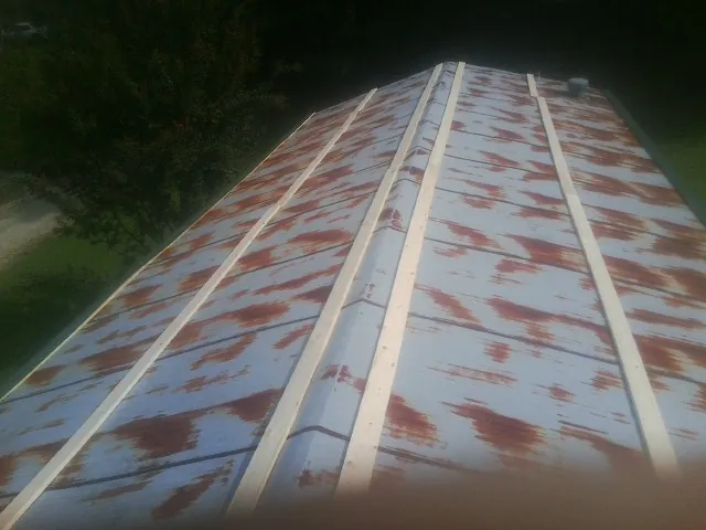 Rusted metal roof panels with new wood purlins before replacement — Storm Damage Roof Repair in North Yarmouth by Roofing Brothers