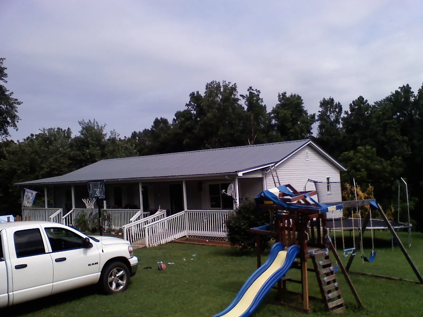 Dark metal roof on a country home with a full length front porch in North Yarmouth