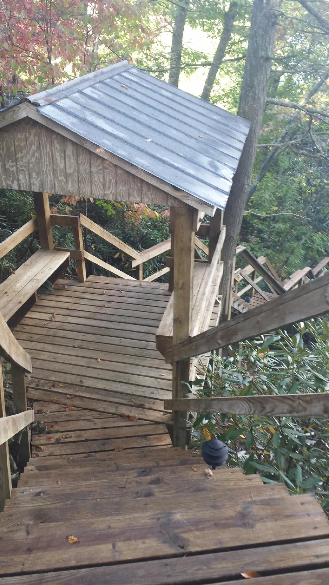 Metal roofed shelter over wooden steps on a wooded walkway — Skylight Repair & Installation work by our crew in North Yarmouth
