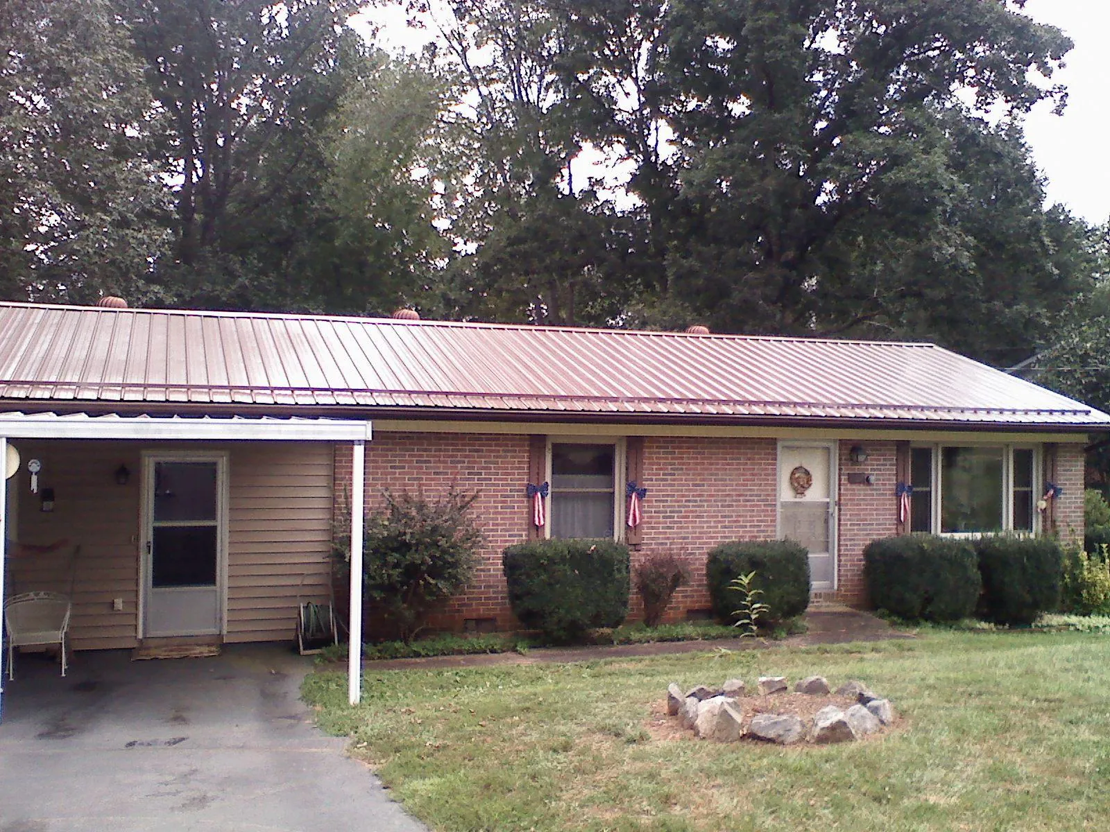Bronze metal roof and carport on a brick ranch home — Roof Repair work by our crew in North Yarmouth